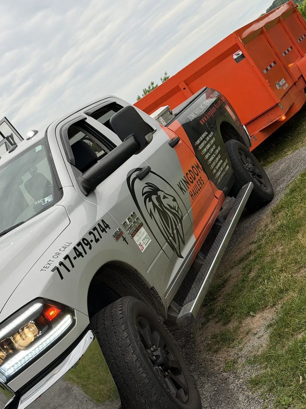 Kingdom Haulers wrapped truck with an orange dump trailer on a job